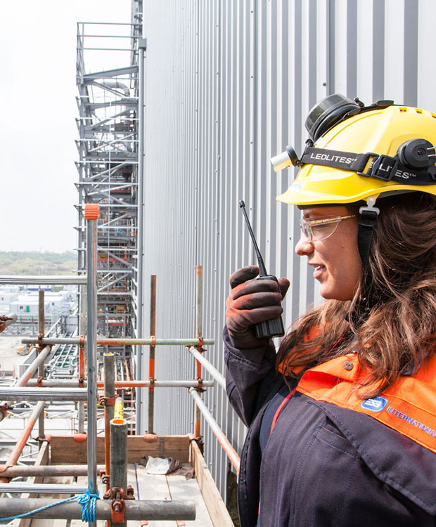 woman with walkie-talkie standing on scaffolding